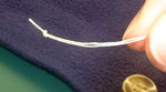 closeup of knotted thread when sewing on a button